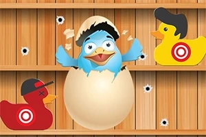 En blå fugl klekker ut av et egg omgitt av to gule plastender med måltavler på seg mot en trebakgrunn med kulehull