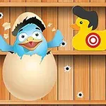 En blå fugl klekker ut av et egg omgitt av to gule plastender med måltavler på seg mot en trebakgrunn med kulehull
