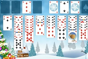 Spillekort lagt ut i et kabalmønster med et vinterlandskap i bakgrunnen, inkludert snødekte trær og en dekorert juletre