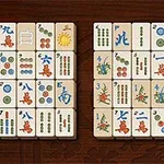 Et sett med mahjong-brikker arrangert på et bord, med ulike symboler og farger