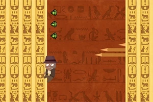 En tegneseriefigur med hatt klatrer på en vegg dekorert med egyptiske hieroglyfer, mens tre grønne diamanter vises på siden