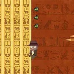 En tegneseriefigur med hatt klatrer på en vegg dekorert med egyptiske hieroglyfer, mens tre grønne diamanter vises på siden